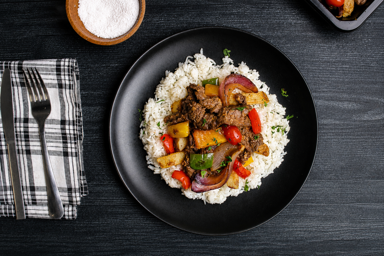 Tender sliced beef sautéed with crispy French fries, red onions, and colorful bell peppers in a savory garlic soy sauce, served over fluffy white rice and finished with fresh herbs for a bold Peruvian-inspired flavor.