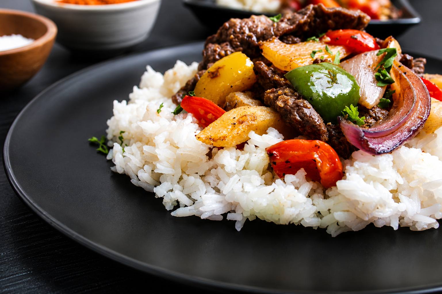 Tender sliced beef sautéed with crispy French fries, red onions, and colorful bell peppers in a savory garlic soy sauce, served over fluffy white rice and finished with fresh herbs for a bold Peruvian-inspired flavor.